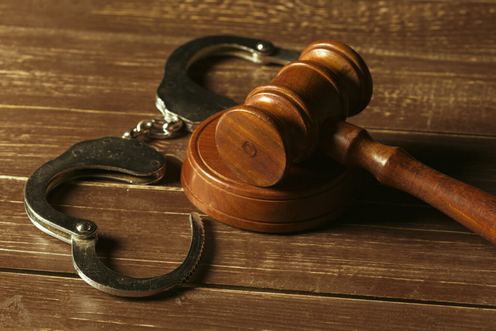 Especialista em compliance bancário analisando processos judiciais para identificar mandados de prisão e mitigar riscos legais.
