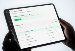 Tela da plataforma Judit.io exibida em um tablet com painel de consultas históricas de processos jurídicos.