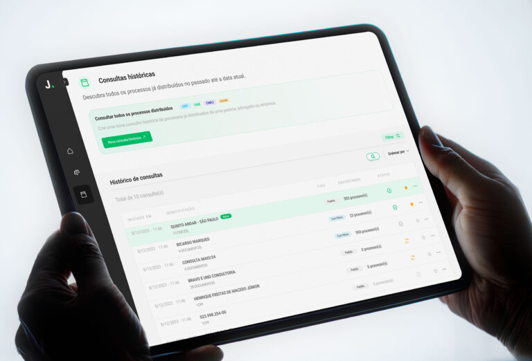 Tela da plataforma Judit.io exibida em um tablet com painel de consultas históricas de processos jurídicos.